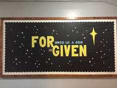 a sign that says for us a son is given in yellow and black with stars