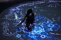 a woman sitting on top of a floor covered in blue lights