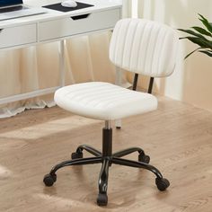 a white office chair sitting on top of a hard wood floor next to a desk