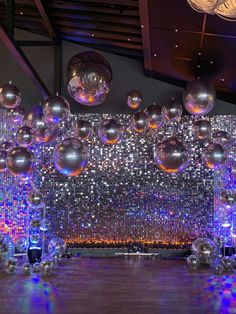 a large room filled with lots of shiny silver balls and disco ball chandeliers