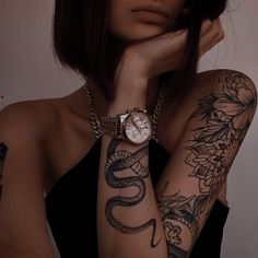 a woman with tattoos and a watch on her arm