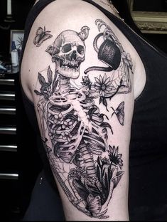 a woman with a skull and flowers tattoo on her arm