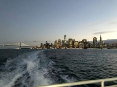 the city skyline as seen from a boat in the water at night time with lights on