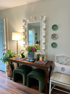 a living room filled with furniture and a mirror on the wall next to a table