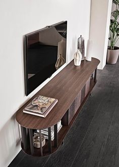 a living room with a large tv mounted on the wall next to a wooden table