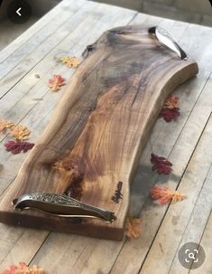 a knife holder made out of wood on a wooden table with leaves scattered around it