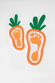 two orange carrots with feet and toes painted on the bottom one is green, while the other is white