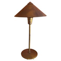 an antique brass table lamp with a brown shade on it's base and a white background