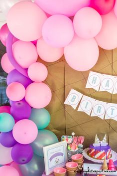 a birthday party with balloons, cake and cupcakes