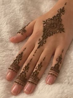 a woman's hand with henna tattoos on it