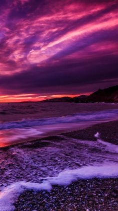 the sun is setting over the ocean with purple clouds