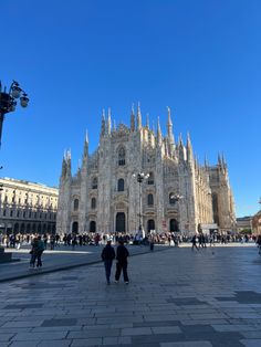 people are walking around in front of the cathedral