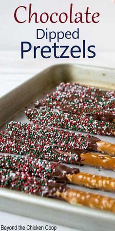 chocolate and sprinkle covered pretzels in a baking pan with candy canes