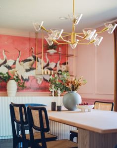 a dining room table with chairs and a vase on it