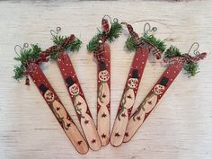 four wooden spoons decorated with christmas decorations