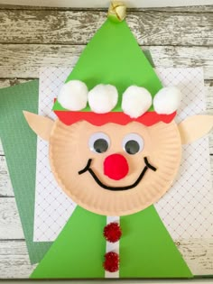 a paper plate with a santa clause hat on it and cotton balls hanging from the top