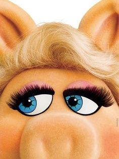 the miss piggy face has long blonde hair and big blue eyes with pink eyelashes