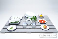 a wooden table topped with plates and bowls filled with food