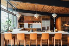 a kitchen with an island and bar stools in front of the countertop area