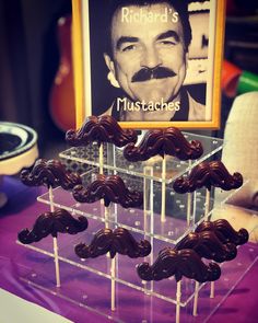 chocolate lollipops are arranged in the shape of mustaches on a stand