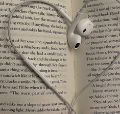 an open book with headphones laying on top of each other in the shape of a heart