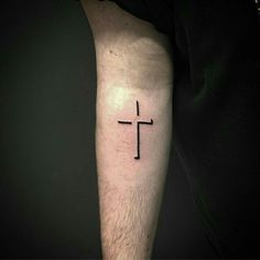 a man's arm with a cross tattoo on the left side of his arm