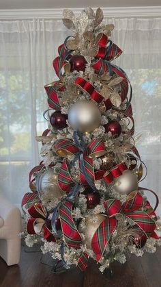 a christmas tree decorated with red, silver and gold ornaments