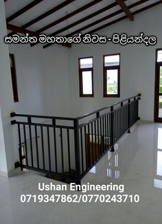 an empty room with white tile floors and black railings