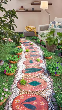 a garden path made out of pebbles and stones with plants on each side in the center