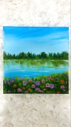 a painting of a lake with flowers in the foreground