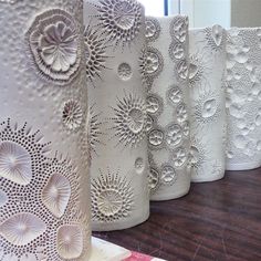 five white vases sitting on top of a wooden table