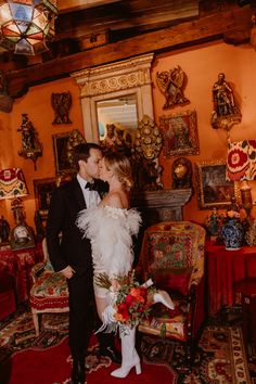 a bride and groom are kissing in an ornate room with red rugs on the floor