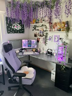 an office with purple flowers hanging from the ceiling and two computer desks in front of them