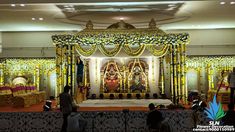 the stage is decorated with yellow and white flowers, gold trimmings and decorations