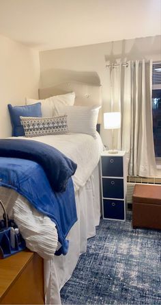 a bedroom with blue carpet and white bedding