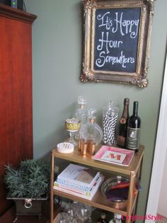 a shelf filled with bottles and glasses next to a chalkboard that says happy hour somewhere