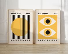 two posters with the names bauhus and austellling on them in front of a white wall