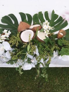 an arrangement of flowers and coconuts on the ground