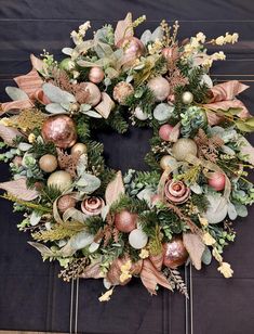 a christmas wreath with ornaments and greenery