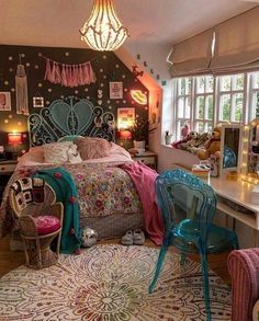 a bedroom decorated in pink, blue and green with a chandelier hanging from the ceiling