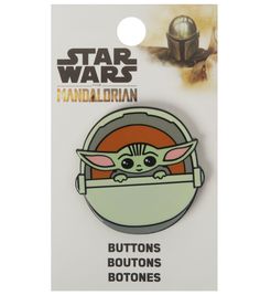 a star wars pin with an image of the child yoda in a spaceship helmet