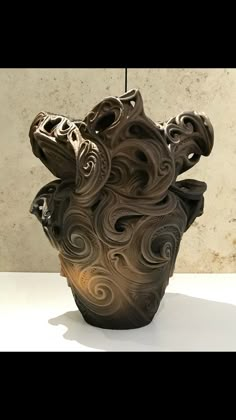 a brown vase sitting on top of a white table