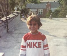 a young boy standing in front of a skateboard ramp