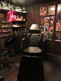 a barber chair in the corner of a room with pictures on the wall and lights above it