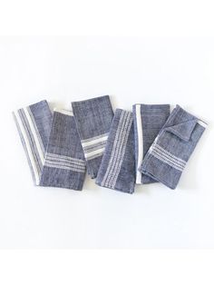 five pieces of blue and white linen folded on top of each other, with stripes in the middle