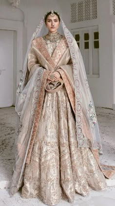 a woman in a wedding dress with a veil on her head standing in an empty room