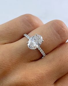 a woman's hand with a diamond ring on top of her finger and an engagement band