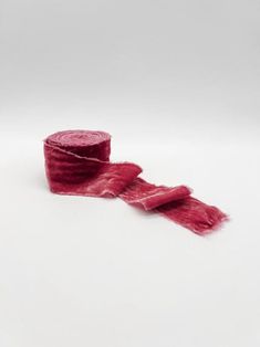 two rolls of red yarn on a white surface