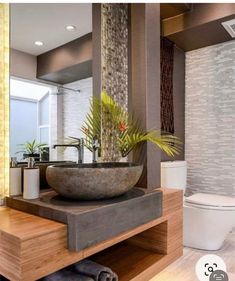 a bathroom with a sink, toilet and shower in the middle of it's wood flooring