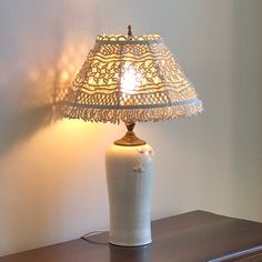 a lamp that is sitting on top of a table next to a dresser with drawers